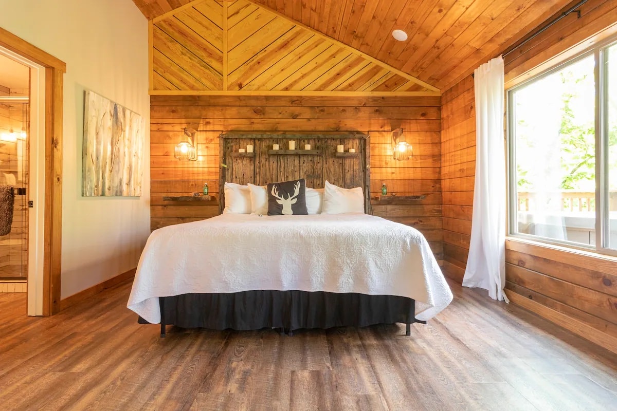A bedroom with a bed with a deer pillow