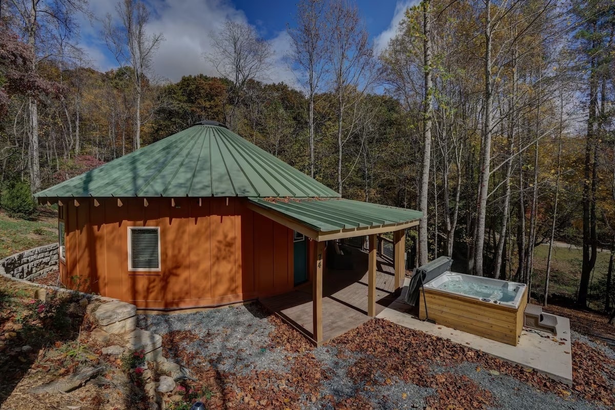 A rustic yurt in the woods with a hottub